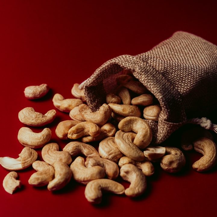 A bag full of cashews on a red background