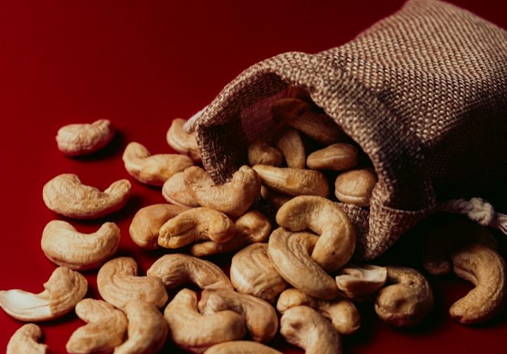 A bag full of cashews on a red background