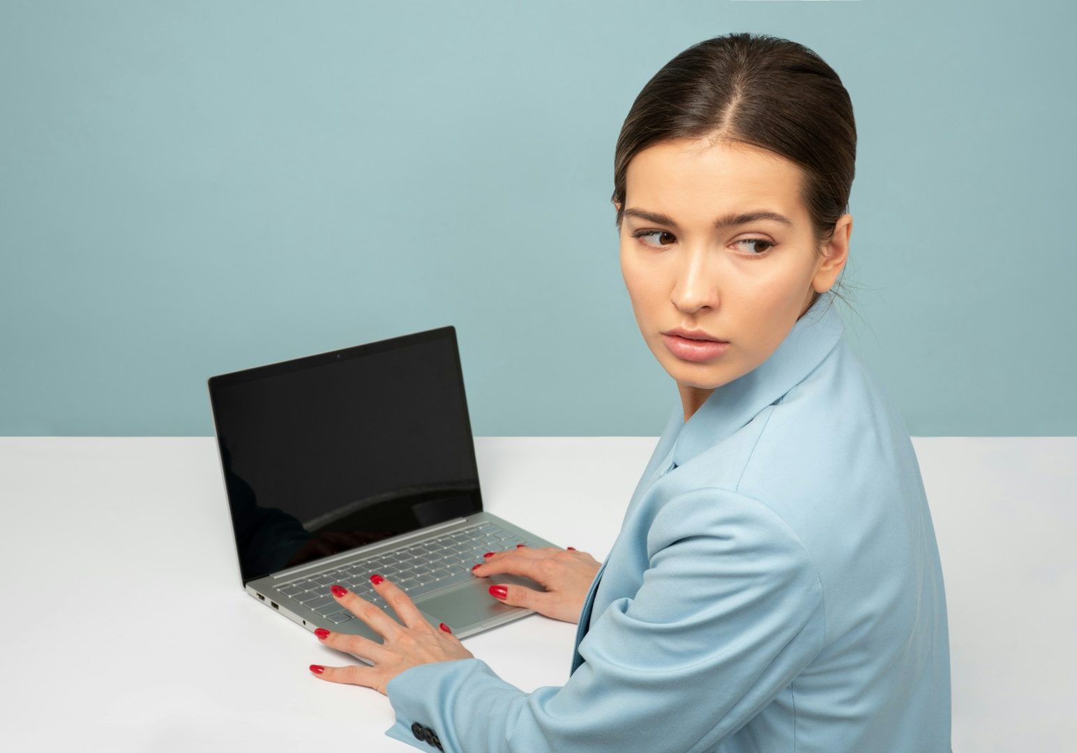 woman using laptop and looking side