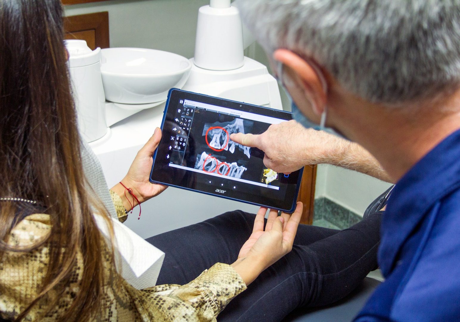 woman in blue denim jeans holding black tablet computer